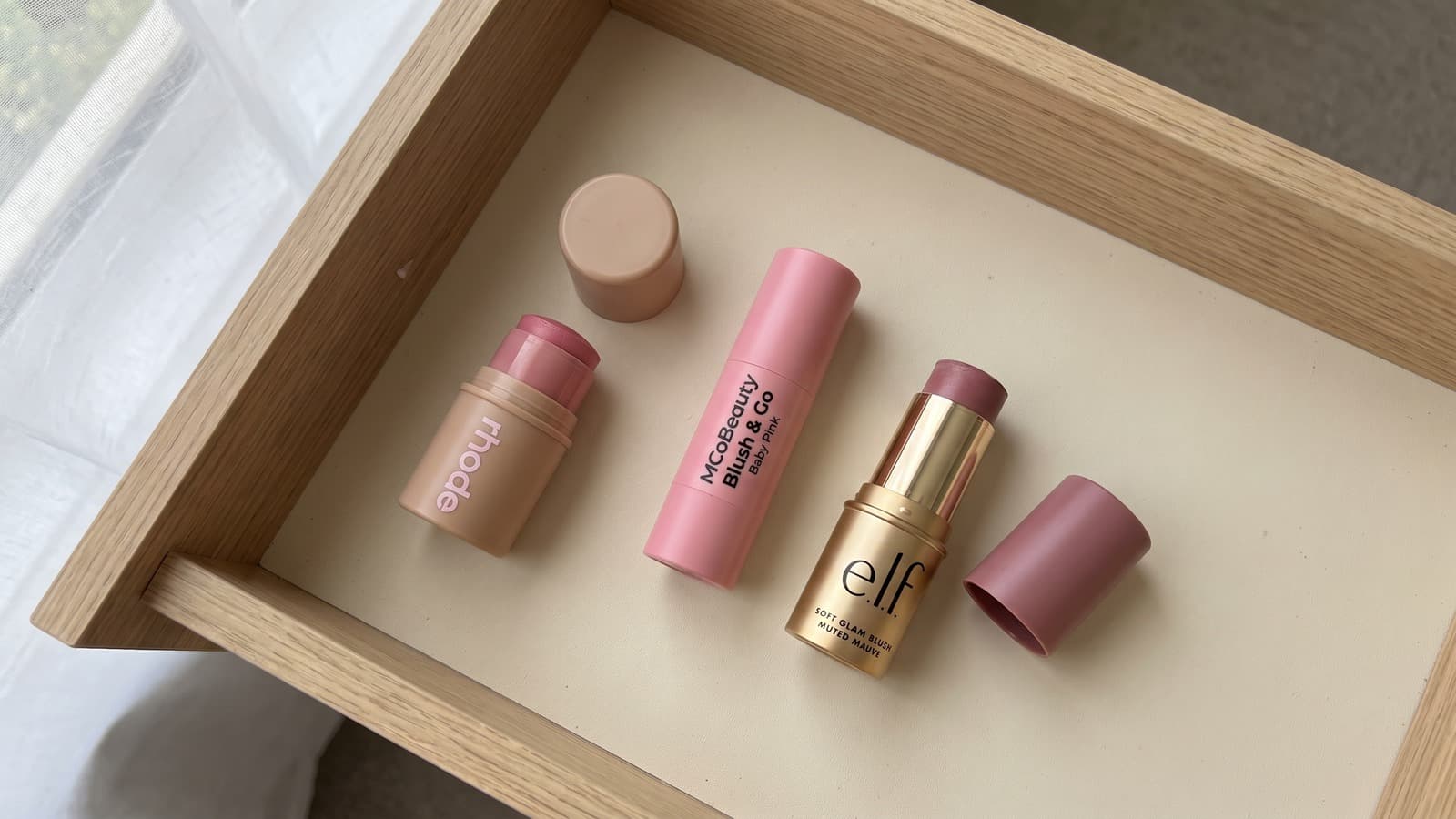 Rhode Pocket Blush, MCoBeauty Blush & Go and e.l.f. Soft Glam cream blush in an open oak drawer